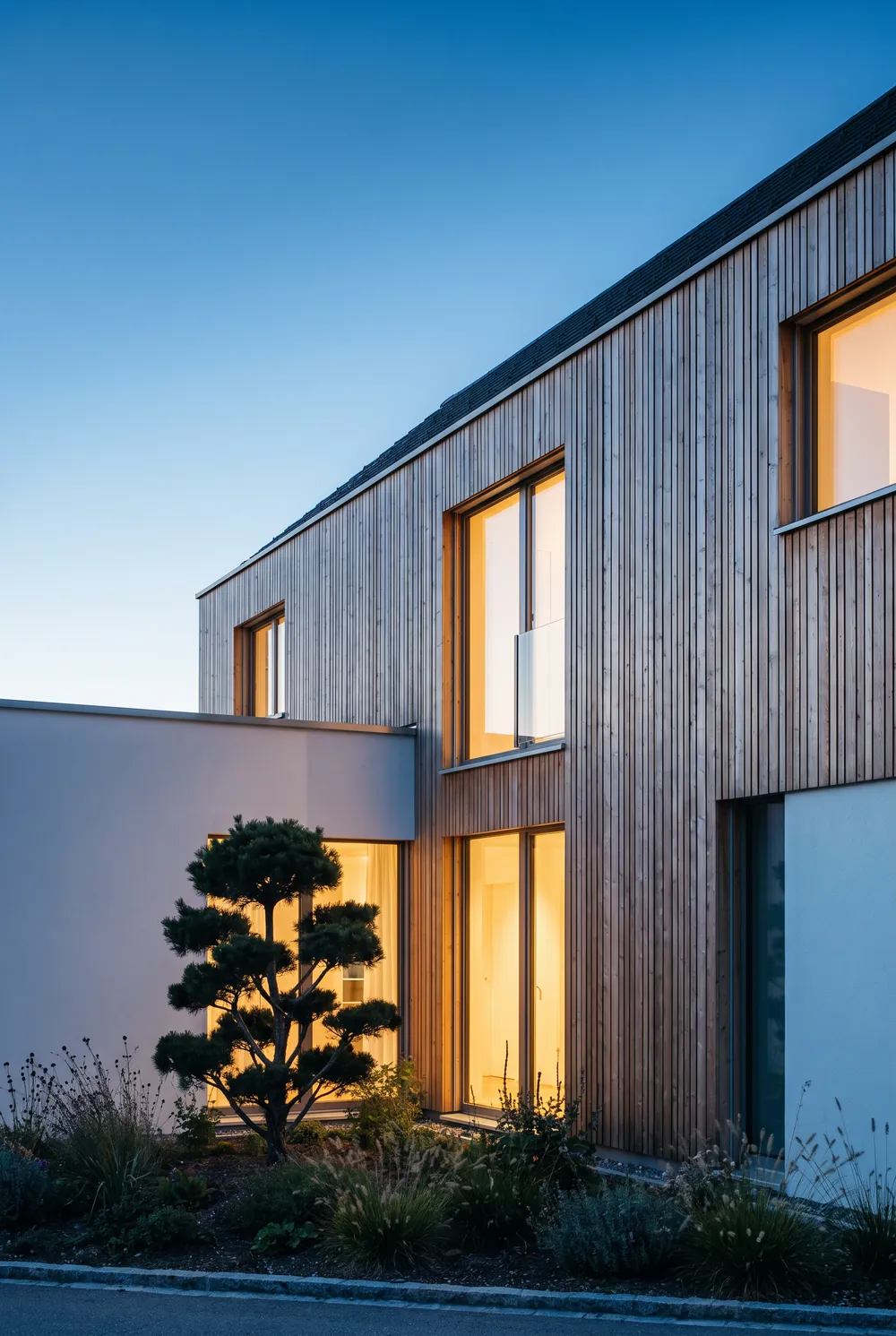 Modernes Einfamilienhaus mit Holzfassade in der Abenddämmerung